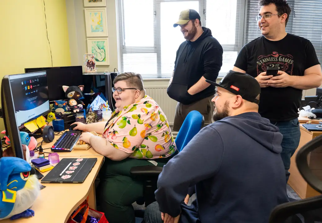 Photo of multiple Stainless Games team members all working on the same computer